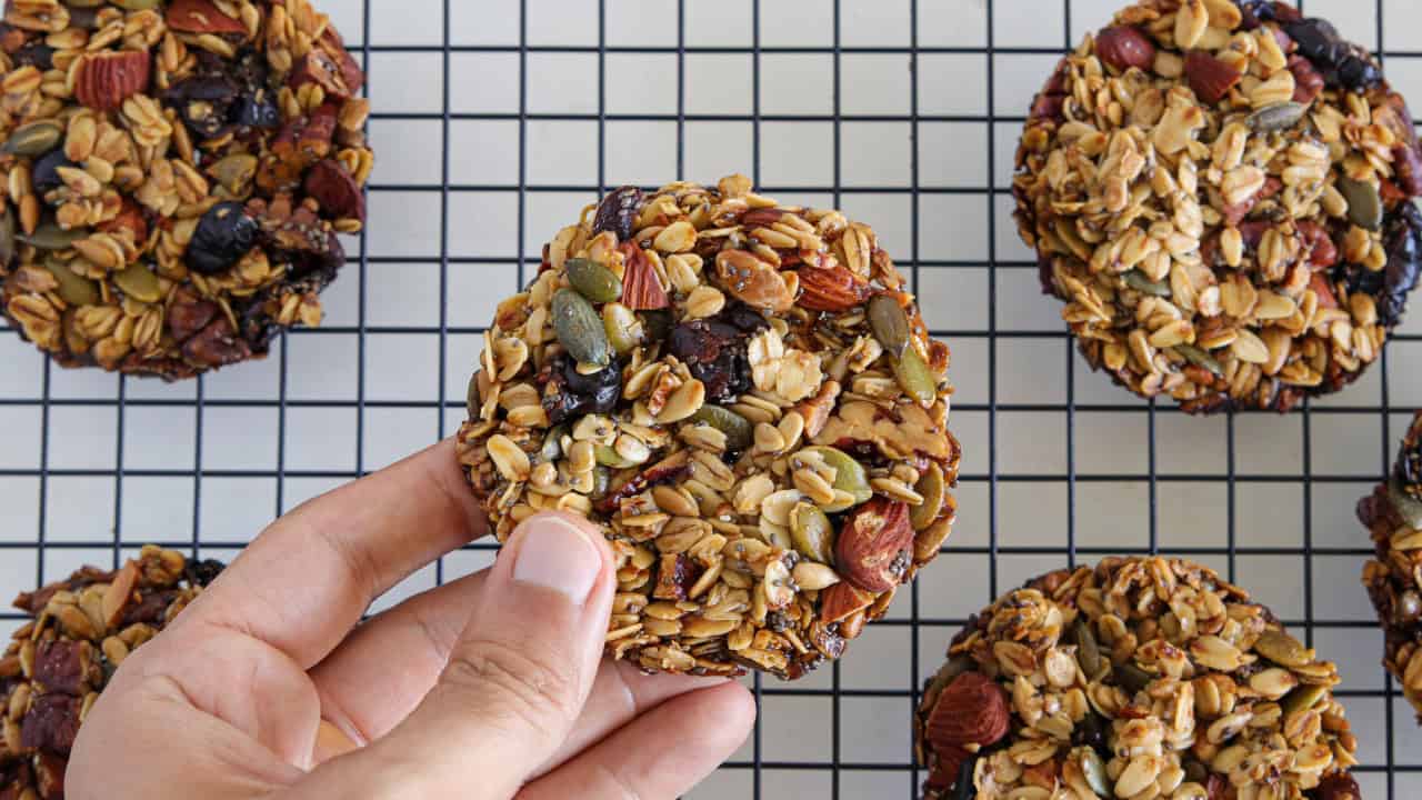 a hand holding granola cookie