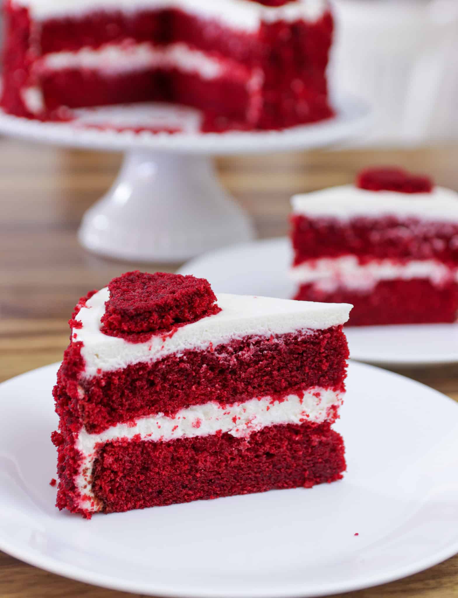 slice of red velvet cake with cream cheese frosting on a plate.