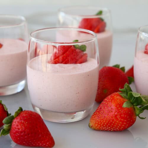 glasses with strawberry mousse and fresh strawberries.