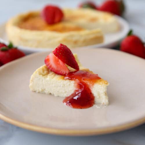 a slice with cottage cheese cheesecake topped with jam and fresh strawberries