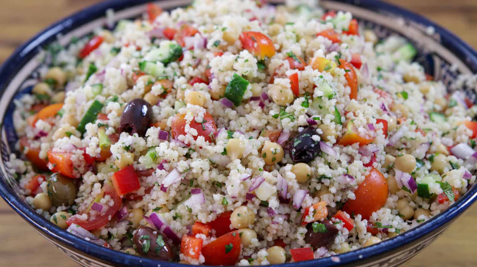 mediterranean couscous salad with cucumber, tomatoes, chickpeaS in a large Moroccan bowl