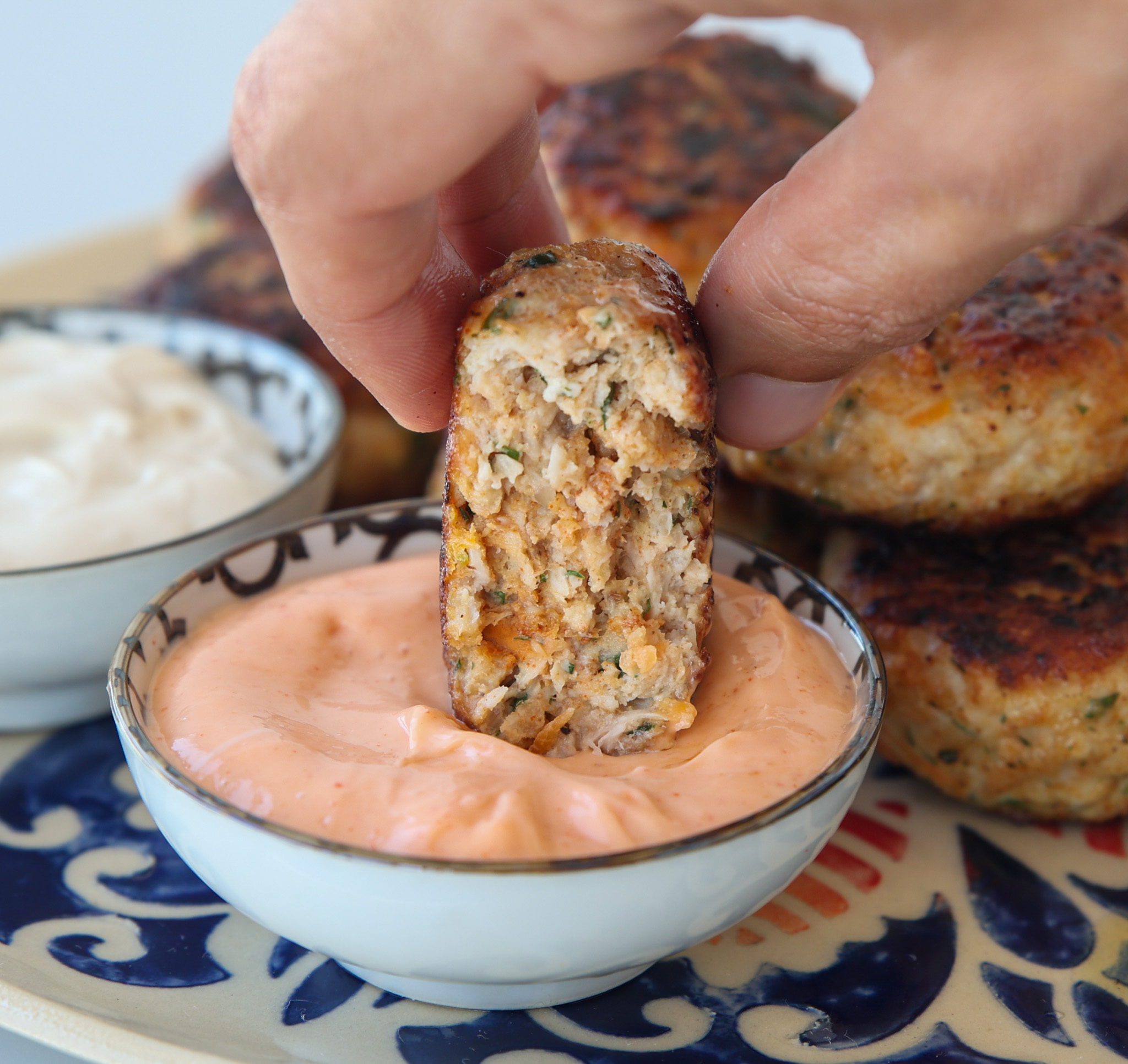 a juicy bitted chicken patty dipped in yogurt tahini sauce