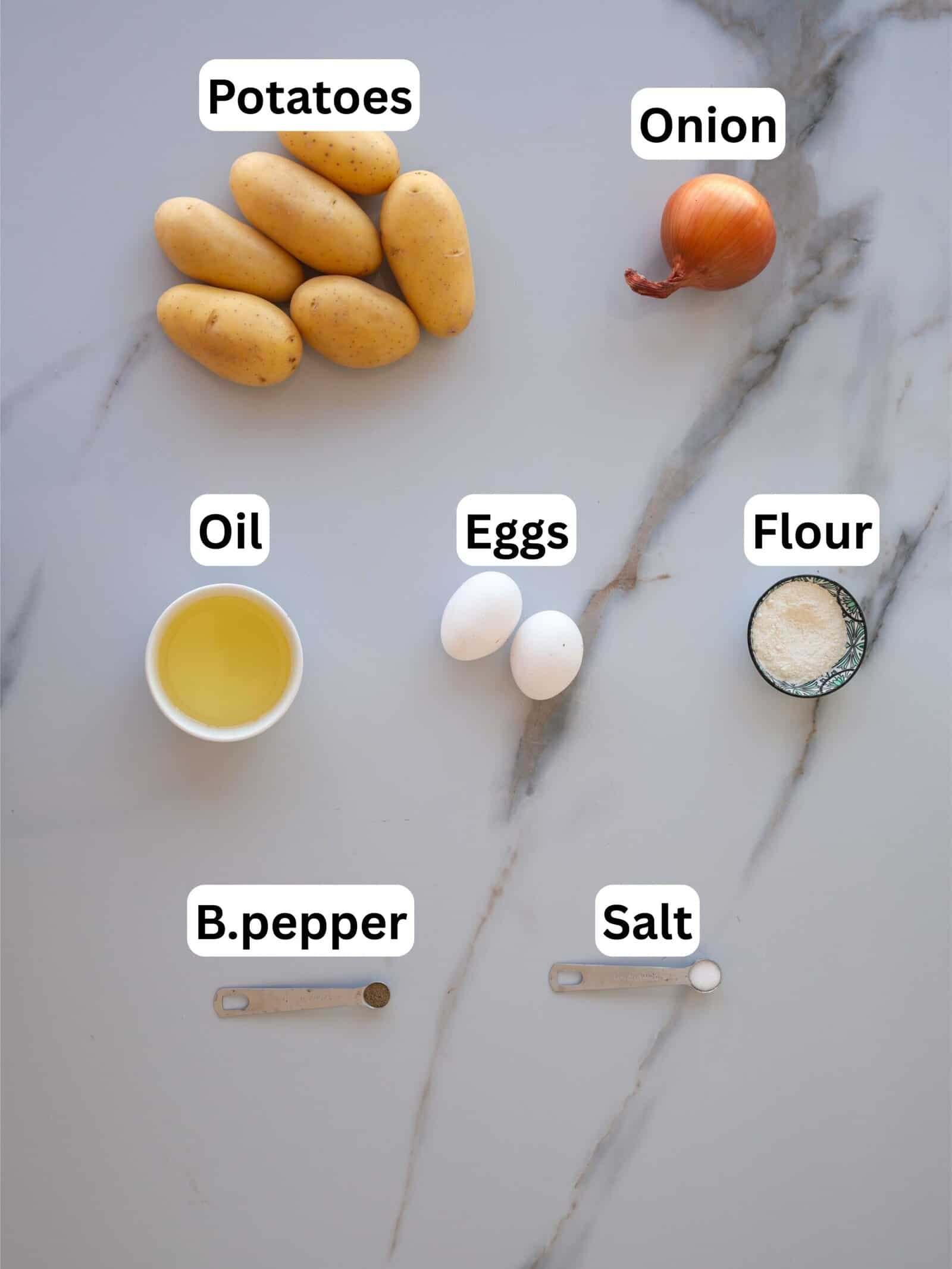 Seven ingredients for a recipe are arranged on a marble surface: potatoes, an onion, a bowl of oil, two eggs, a small bowl of flour, and measuring spoons with black pepper and salt. Each is labeled.