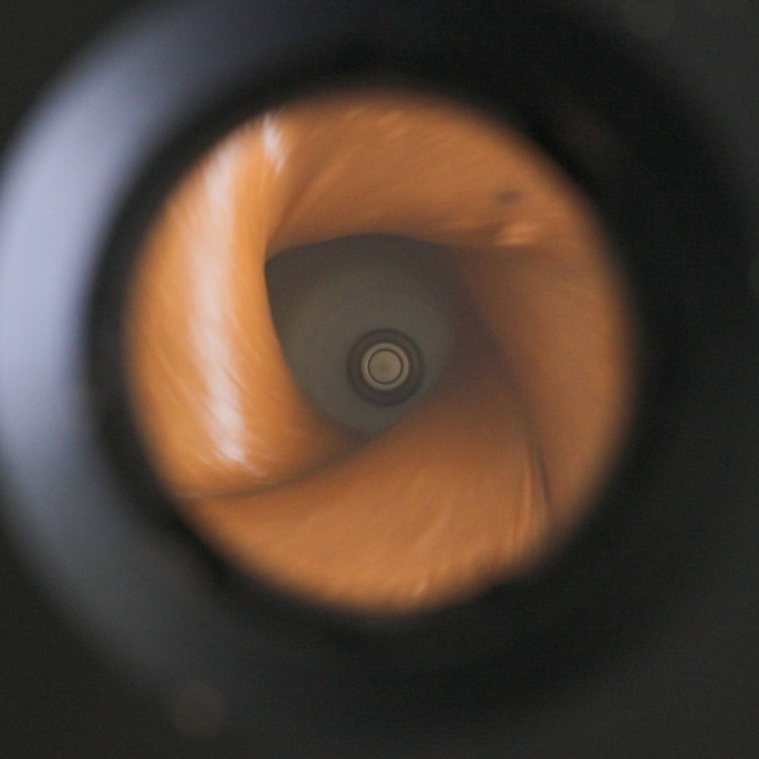 Close-up of blended hazelnut butter inside a food processor bowl.