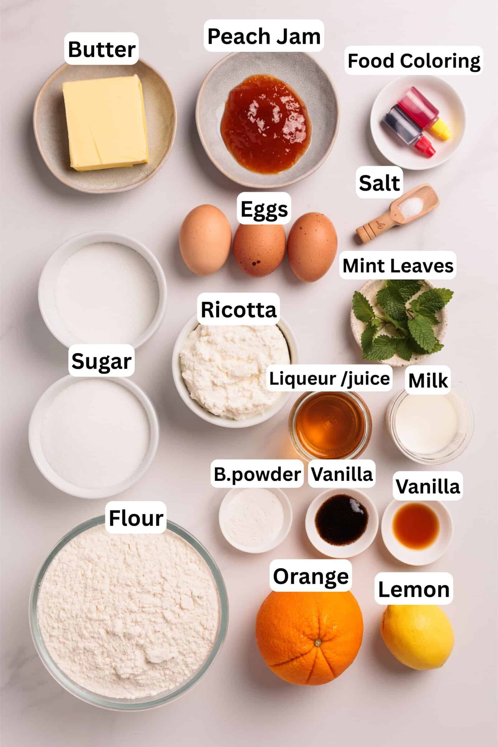 Top-down view of bowls and ingredients for baking, including butter, peach jam, food coloring, eggs, mint leaves, salt, sugar, ricotta, milk, liqueur, vanilla, flour, baking powder, an orange, and a lemon.