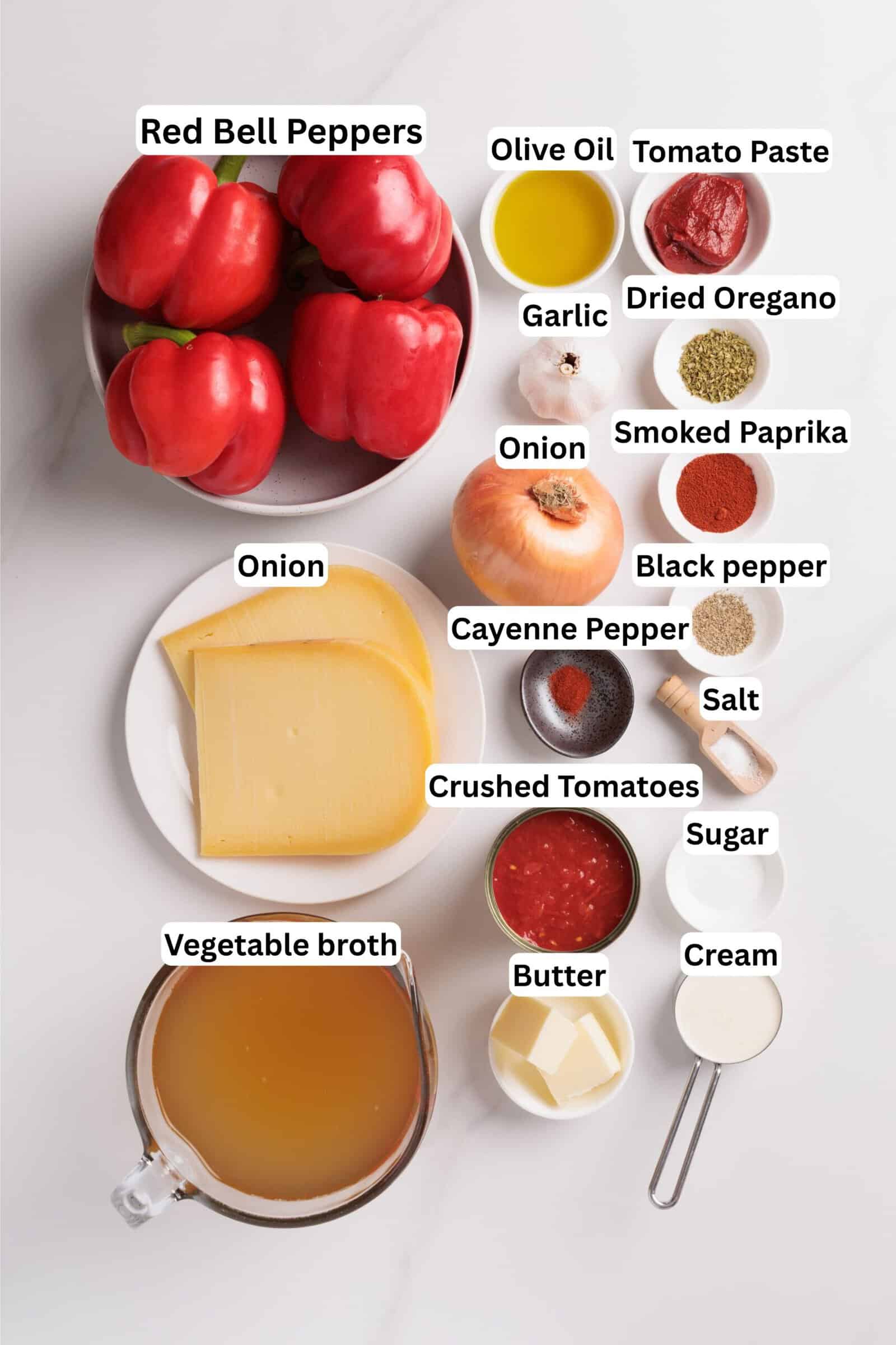 Ingredients for roasted red pepper gouda soup, including red bell peppers, olive oil, tomato paste, garlic, dried oregano, onion, smoked paprika, black pepper, cayenne, salt, crushed tomatoes, sugar, cream, butter, and vegetable broth.