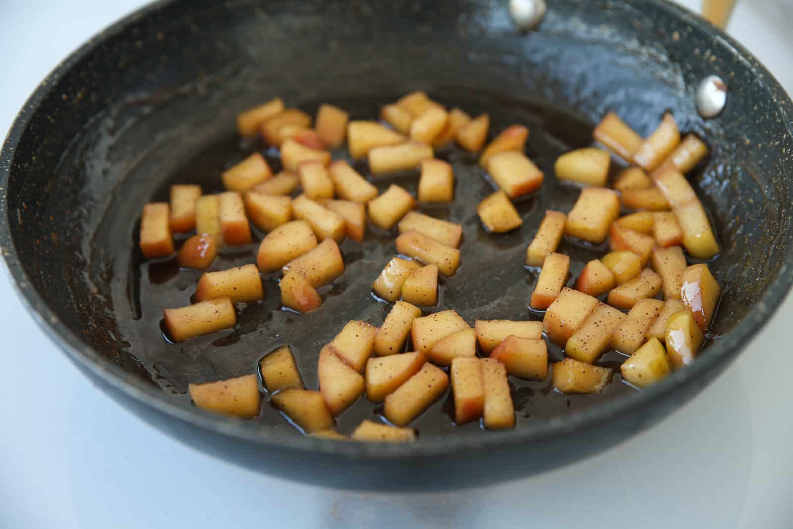 Diced apples cooking in a skillet.